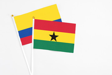 Ghana and Colombia stick flags on white background. High quality fabric, miniature national flag. Peaceful global concept.White floor for copy space.