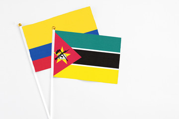 Mozambique and Colombia stick flags on white background. High quality fabric, miniature national...