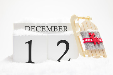 Wooden calendar for December, 12 th day of the winter month. The symbols of winter are snow and...