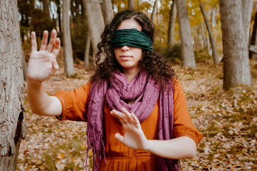 Young woman, dressed in casual clothes, with relaxed attitude, in a forest with autumn colors.