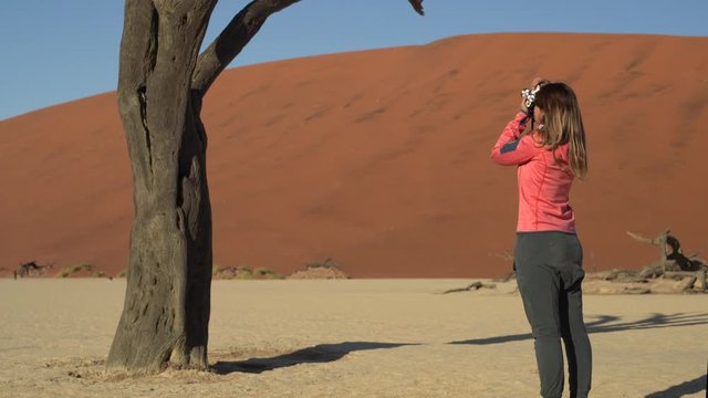 Woman taking photos of tree in Deadvlei, Namibia