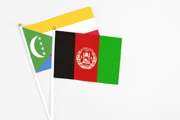 Afghanistan and Comoros stick flags on white background. High quality fabric, miniature national...
