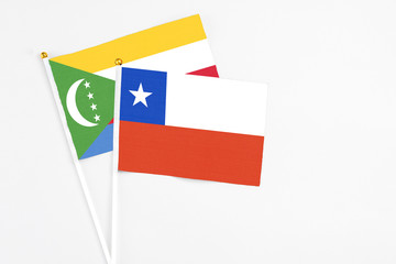 Chile and Comoros stick flags on white background. High quality fabric, miniature national flag. Peaceful global concept.White floor for copy space.