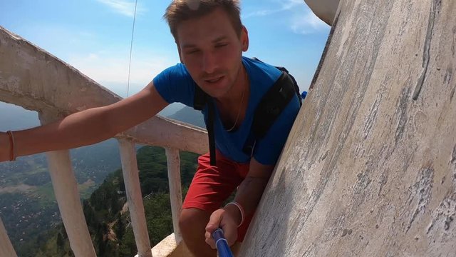 The traveler blogger makes videos for instagram on social networks. He make a dangerous climb to a unique tower 48 meters high located on the Ambuluwawa hill at an altitude of 356 m above sea level.
