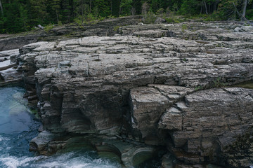 Rock wall with blue rapids below