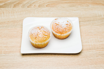 Homemade apple muffins with white sugar powder on wooden table