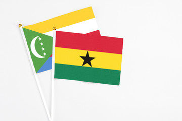Ghana and Comoros stick flags on white background. High quality fabric, miniature national flag. Peaceful global concept.White floor for copy space.