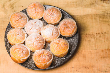 Homemade apple muffins with white sugar powder on wooden table