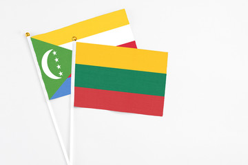 Lithuania and Comoros stick flags on white background. High quality fabric, miniature national flag. Peaceful global concept.White floor for copy space.