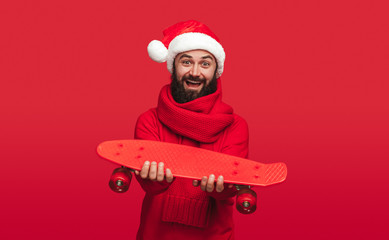 Optimistic hipster giving skateboard to camera on Christmas