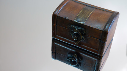 Brown closed wood jewelry box and its reflection on the surface of the mirror. Negative space. Copy space for advertising.