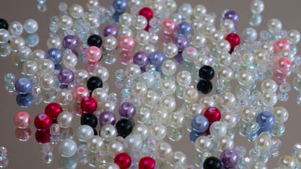 Plastic ball pearls for jewelry making spread out on the surface of the mirror.