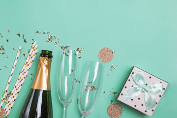 Fototapeta Bottle of a champagne, gift box, golden confetti and glasses. obraz