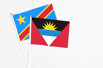 Obraz premium Antigua and Barbuda and Congo stick flags on white background. High quality fabric, miniature national flag. Peaceful global concept.White floor for copy space.