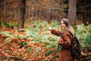 girl with a backpack in the autumn forest