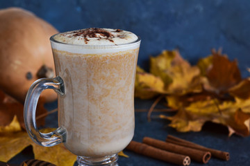 Latte with pumpkin and cinnamon on a concrete background.