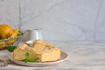 Cheesecake with lemon and pear on a gray concrete background. Horizontal.