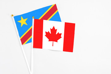 Canada and Congo stick flags on white background. High quality fabric, miniature national flag. Peaceful global concept.White floor for copy space.
