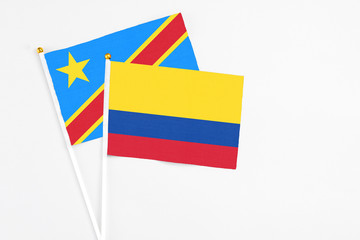 Colombia and Congo stick flags on white background. High quality fabric, miniature national flag. Peaceful global concept.White floor for copy space.