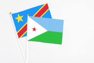 Djibouti and Congo stick flags on white background. High quality fabric, miniature national flag. Peaceful global concept.White floor for copy space.
