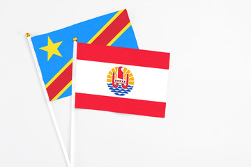 French Polynesia and Congo stick flags on white background. High quality fabric, miniature national flag. Peaceful global concept.White floor for copy space.