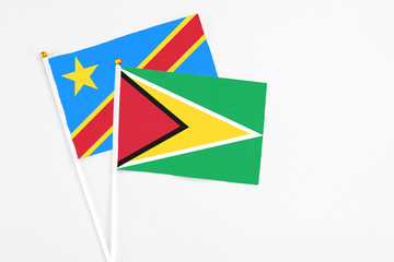 Guyana and Congo stick flags on white background. High quality fabric, miniature national flag. Peaceful global concept.White floor for copy space.