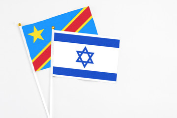 Israel and Congo stick flags on white background. High quality fabric, miniature national flag. Peaceful global concept.White floor for copy space.