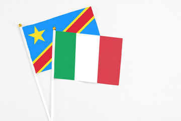 Italy and Congo stick flags on white background. High quality fabric, miniature national flag. Peaceful global concept.White floor for copy space.