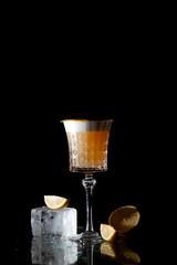 classic amber cocktail with citrus and ice on a black background