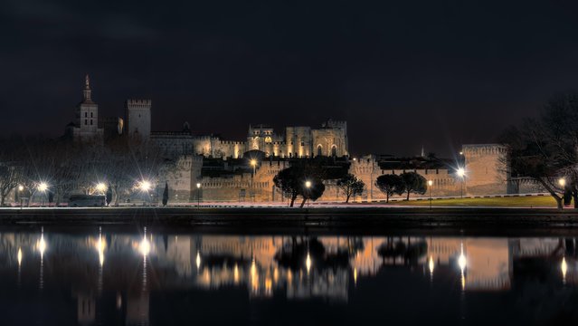 Historic region of Avignon reflecting in the Rh̫ne River during nighttime