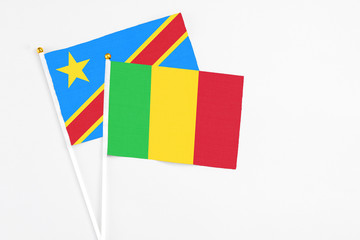 Mali and Congo stick flags on white background. High quality fabric, miniature national flag. Peaceful global concept.White floor for copy space.