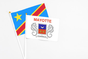 Mayotte and Congo stick flags on white background. High quality fabric, miniature national flag. Peaceful global concept.White floor for copy space.