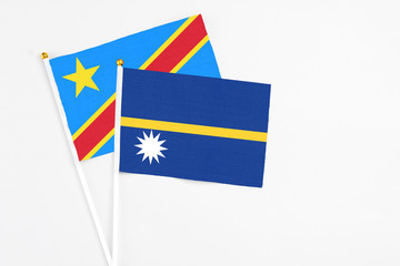 Nauru and Congo stick flags on white background. High quality fabric, miniature national flag. Peaceful global concept.White floor for copy space.