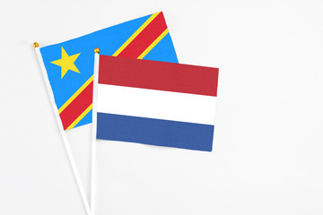 Netherlands and Congo stick flags on white background. High quality fabric, miniature national flag. Peaceful global concept.White floor for copy space.