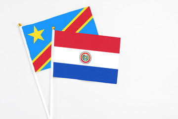 Paraguay and Congo stick flags on white background. High quality fabric, miniature national flag. Peaceful global concept.White floor for copy space.