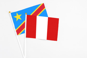 Peru and Congo stick flags on white background. High quality fabric, miniature national flag. Peaceful global concept.White floor for copy space.