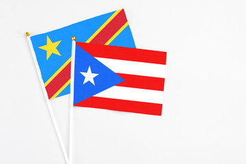 Fototapeta premium Puerto Rico and Congo stick flags on white background. High quality fabric, miniature national flag. Peaceful global concept.White floor for copy space.