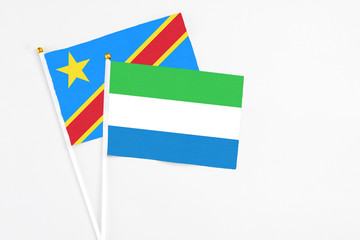 Sierra Leone and Congo stick flags on white background. High quality fabric, miniature national flag. Peaceful global concept.White floor for copy space.