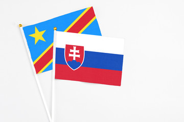 Slovakia and Congo stick flags on white background. High quality fabric, miniature national flag. Peaceful global concept.White floor for copy space.