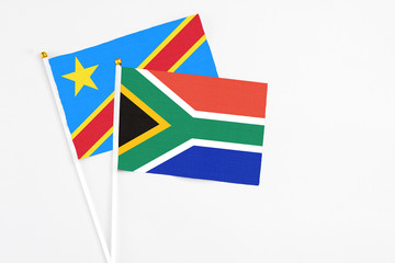 South Africa and Congo stick flags on white background. High quality fabric, miniature national flag. Peaceful global concept.White floor for copy space.