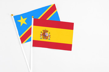 Spain and Congo stick flags on white background. High quality fabric, miniature national flag. Peaceful global concept.White floor for copy space.