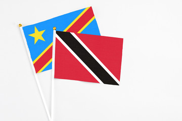 Fototapeta na wymiar Trinidad And Tobago and Congo stick flags on white background. High quality fabric, miniature national flag. Peaceful global concept.White floor for copy space.
