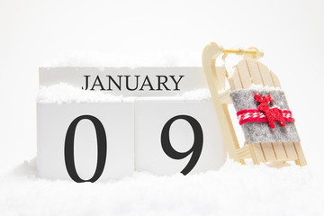 Wooden calendar for January, 9 th day of the winter month. The symbols of winter are snow and...