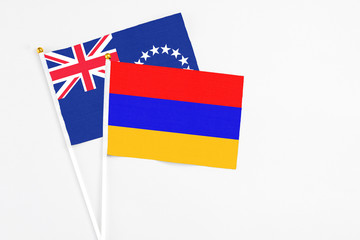 Armenia and Cook Islands stick flags on white background. High quality fabric, miniature national flag. Peaceful global concept.White floor for copy space.