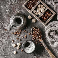 Coffee cup and coffee beans on dark stone background.