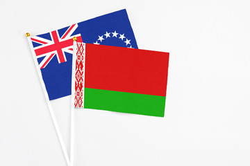 Belarus and Cook Islands stick flags on white background. High quality fabric, miniature national flag. Peaceful global concept.White floor for copy space.