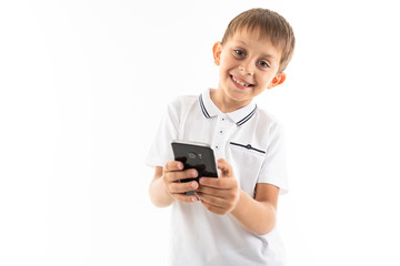 Portrait of happy caucasian boy chatting with his friends or playing phone games and smiles