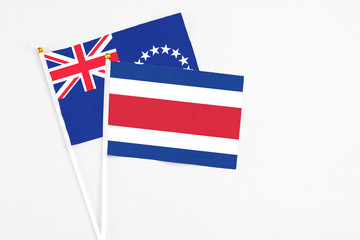 Costa Rica and Cook Islands stick flags on white background. High quality fabric, miniature national flag. Peaceful global concept.White floor for copy space.