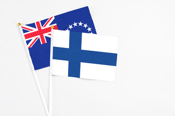 Finland and Cook Islands stick flags on white background. High quality fabric, miniature national flag. Peaceful global concept.White floor for copy space.