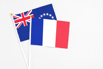 France and Cook Islands stick flags on white background. High quality fabric, miniature national flag. Peaceful global concept.White floor for copy space.